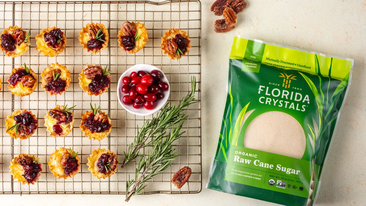 cranberry pecan brie bites next to a bag of organic raw cane sugar
